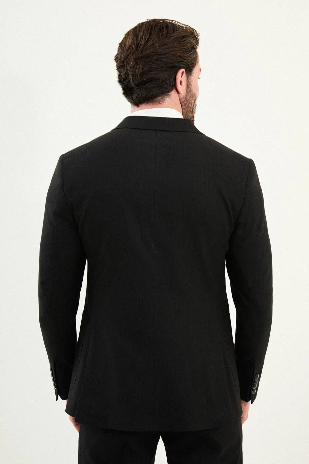 Men’s black mono-collar slim-fit suit with band/mandarin neckline, matte finish tailoring, single-breasted jacket styled with a white turtleneck, travel-ready stretch wool-viscose blend.