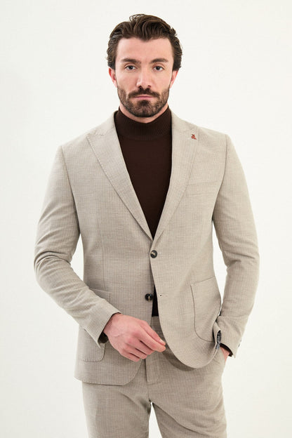 Men’s beige slim-fit mono-collar (mandarin collar) winter suit with minimalist single-breasted jacket, matte micro-texture active-recovery fabric, styled with a dark brown turtleneck.