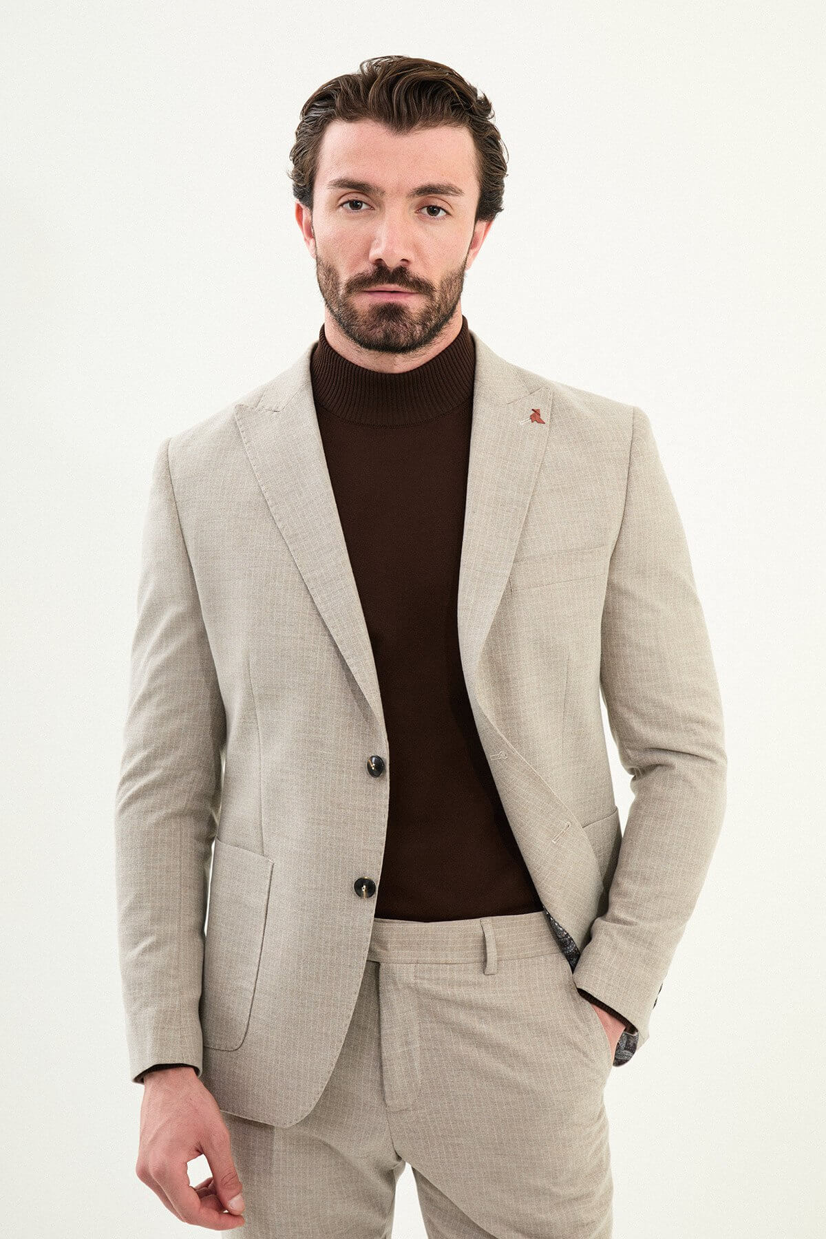 Men’s beige slim-fit mono-collar (mandarin collar) winter suit with minimalist single-breasted jacket, matte micro-texture active-recovery fabric, styled with a dark brown turtleneck.