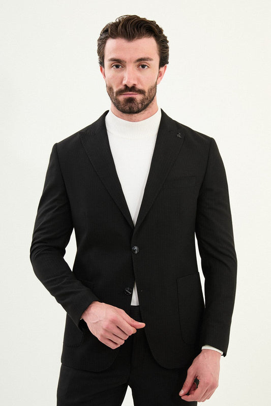 Men’s black mono-collar slim-fit suit with band/mandarin neckline, matte finish tailoring, single-breasted jacket styled with a white turtleneck, travel-ready stretch wool-viscose blend.