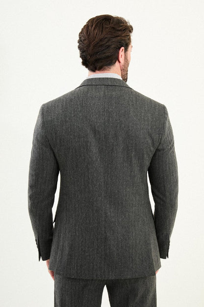 Men’s gray herringbone slim-fit suit with structured shoulders and tailored waist, high-wool blend fabric with stretch for winter wear, styled with a light gray fine-gauge turtleneck