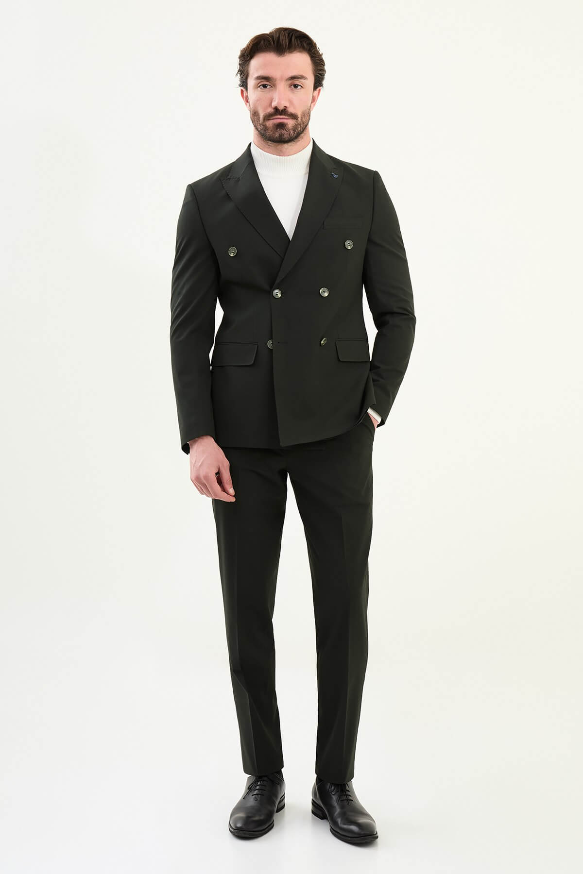 Men’s matte obsidian black slim-fit double-breasted 6x2 suit with peak lapels, cotton-wool-viscose blend with 4-way stretch for wrinkle-resistant wear, styled with a crisp white turtleneck.