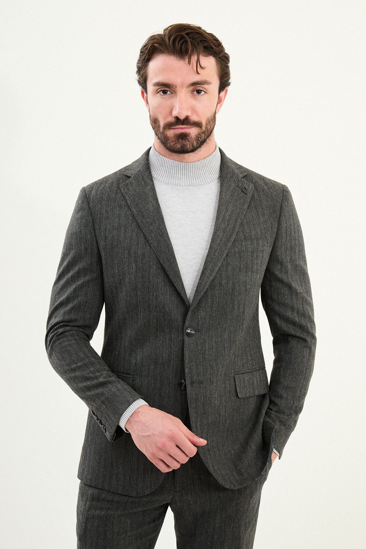 Men’s gray herringbone slim-fit suit with structured shoulders and tailored waist, high-wool blend fabric with stretch for winter wear, styled with a light gray fine-gauge turtleneck