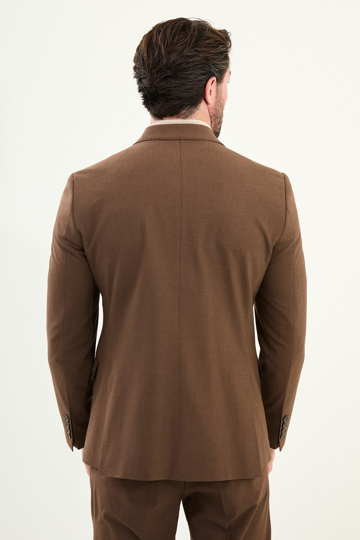 Men’s deep brown slim-fit double-breasted 6x2 suit with peak lapels and patch pockets, cotton-wool-viscose blend with 4-way stretch for wrinkle-resistant wear, styled with a cream turtleneck.