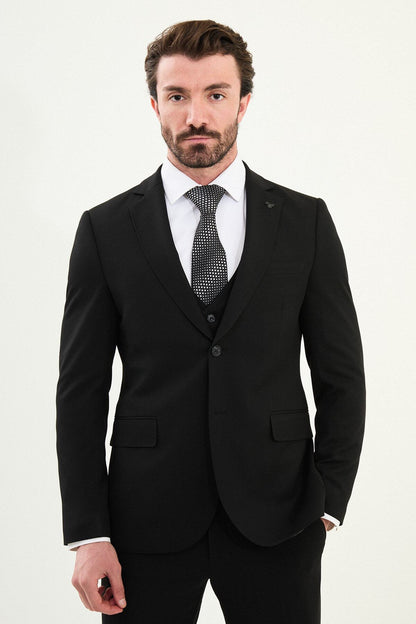 Men’s matte black slim-fit three-piece wool-blend winter suit with single-breasted jacket, notch lapels with AMF stitching, high-cut five-button waistcoat, tapered trousers, and black origami lapel pin.