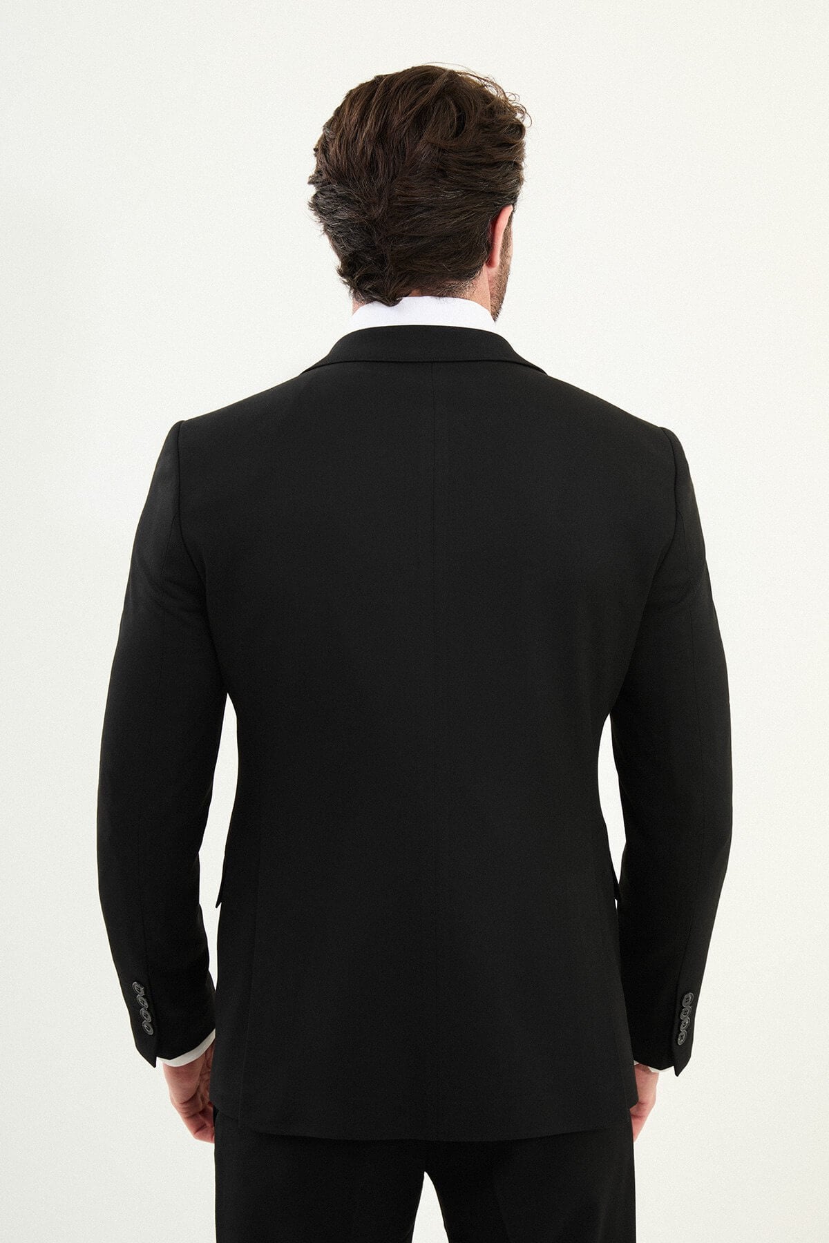 Men’s matte black slim-fit three-piece wool-blend winter suit with single-breasted jacket, notch lapels with AMF stitching, high-cut five-button waistcoat, tapered trousers, and black origami lapel pin.