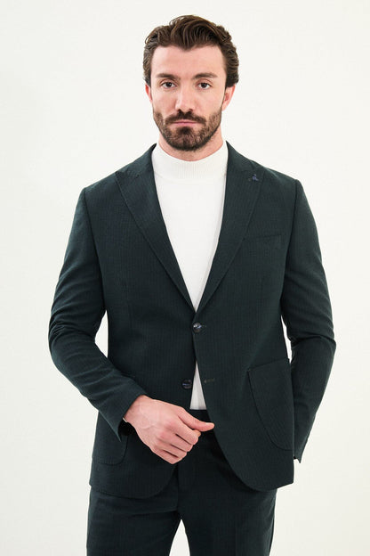 Men’s dark green slim-fit mono-collar (mandarin collar) suit with single-breasted jacket, matte micro-texture fabric, and clean minimalist tailoring designed for turtleneck layering.