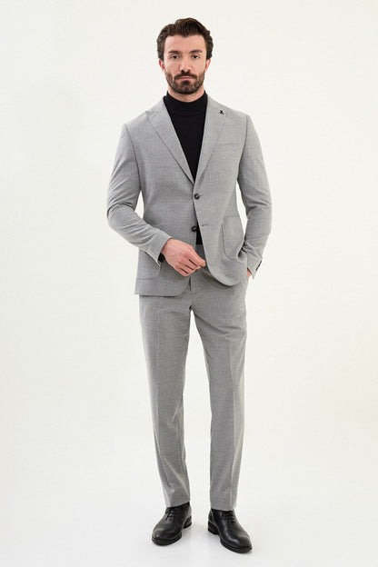 Men’s gray slim-fit mono-collar (mandarin collar) performance suit with 2-button single-breasted jacket, minimalist patch pockets, matte micro-texture fabric, styled with a black turtleneck.