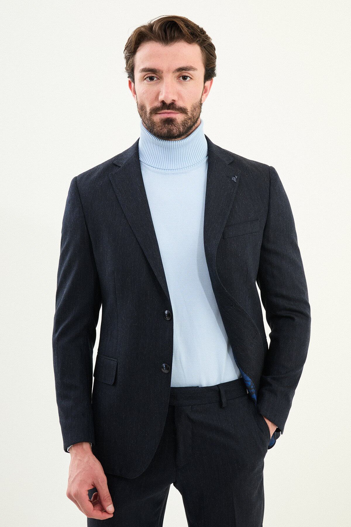 Men’s matte navy blue slim-fit single-breasted wool-blend suit with notch lapels and two-button closure, high-wool fabric with stretch for wrinkle-resistant winter wear, styled with a light blue turtleneck.